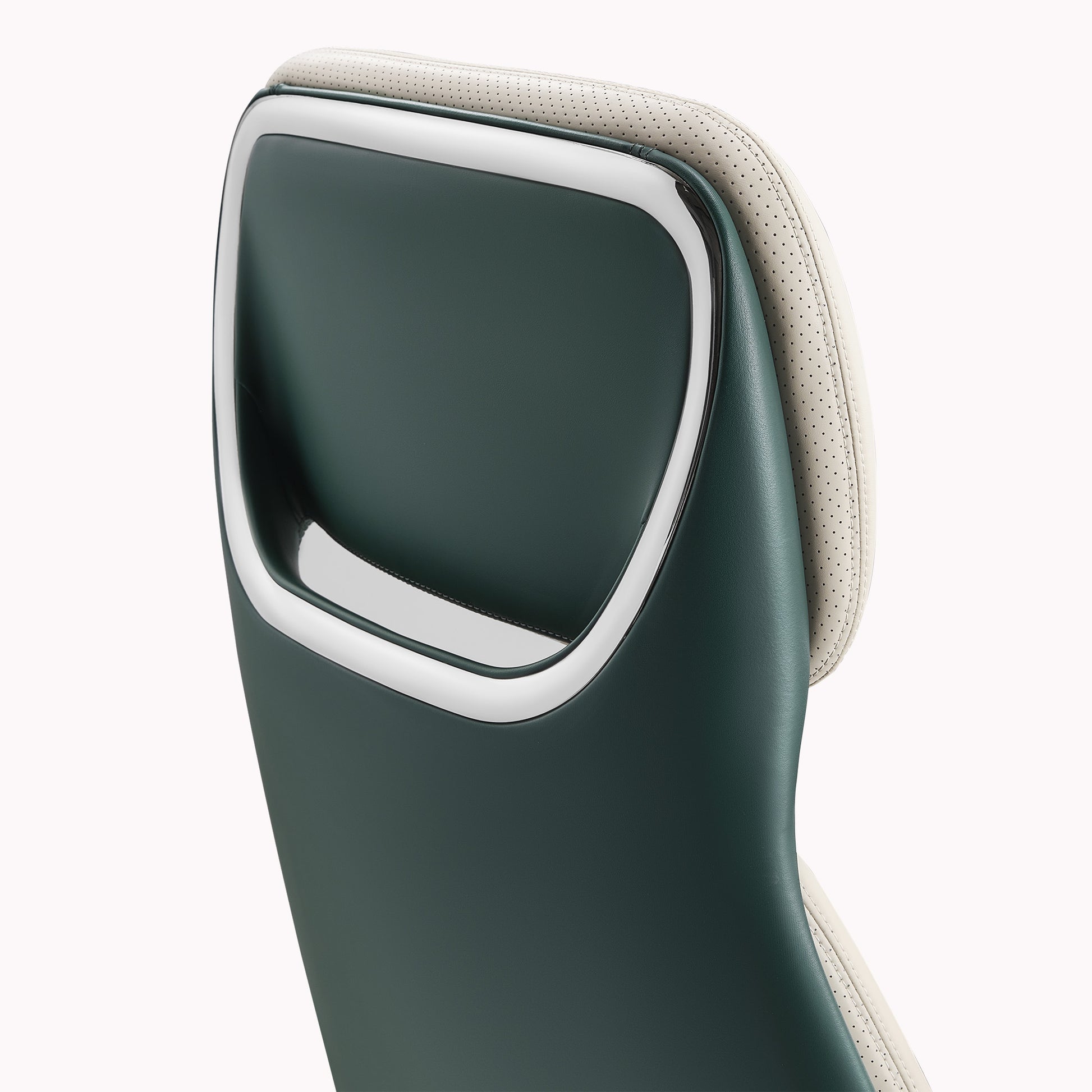 Eureka Ergonomic Close-up of Serene executive chair headrest: dark green exterior, cream perforated Napa leather interior, chrome trim detail.