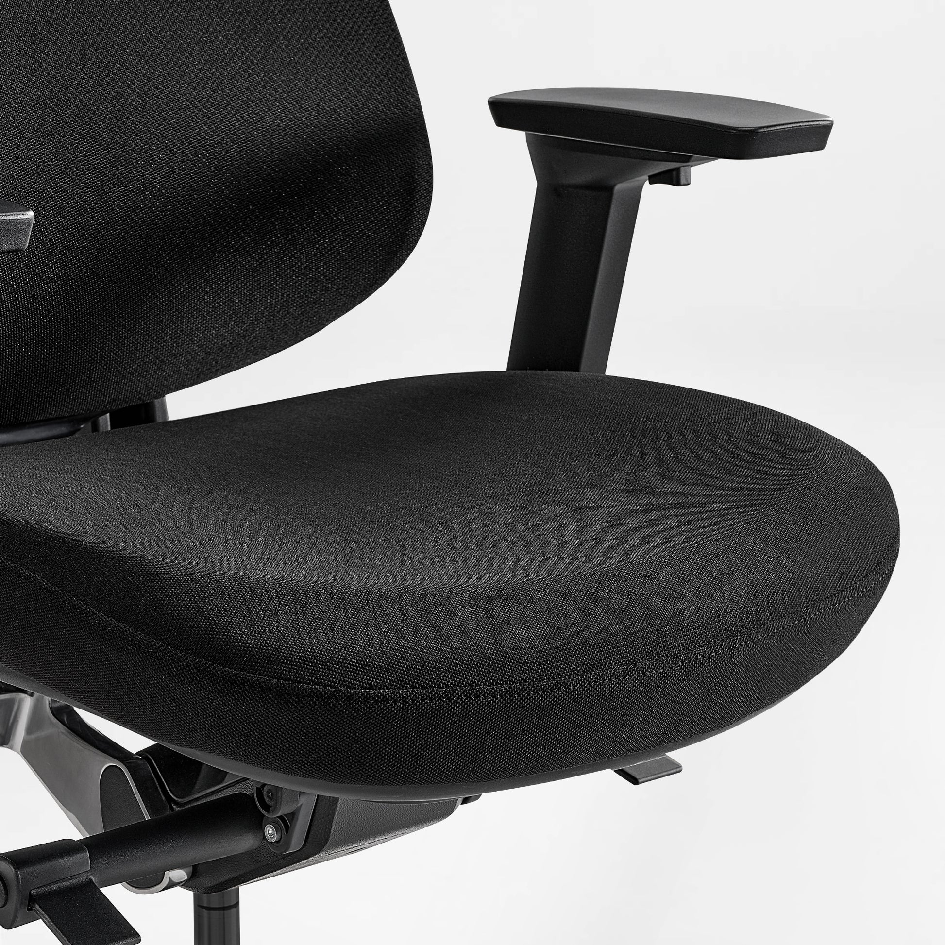 Eureka Ergonomic Lira black ergonomic office chair close-up: textured fabric seat, armrest, and adjustment levers visible.