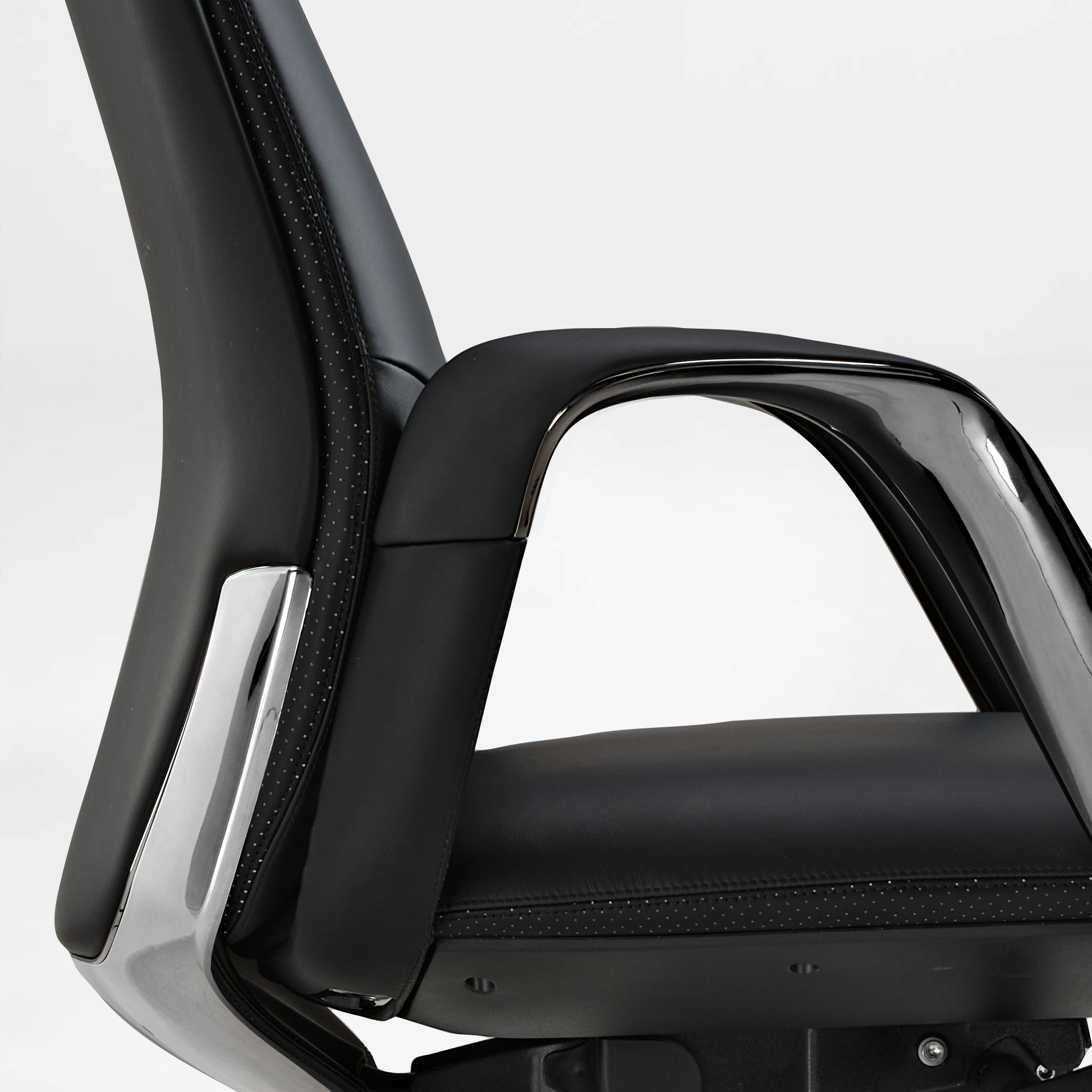 Eureka Ergonomic Serene black Napa leather executive chair armrest and perforated seat detail with chrome accents.