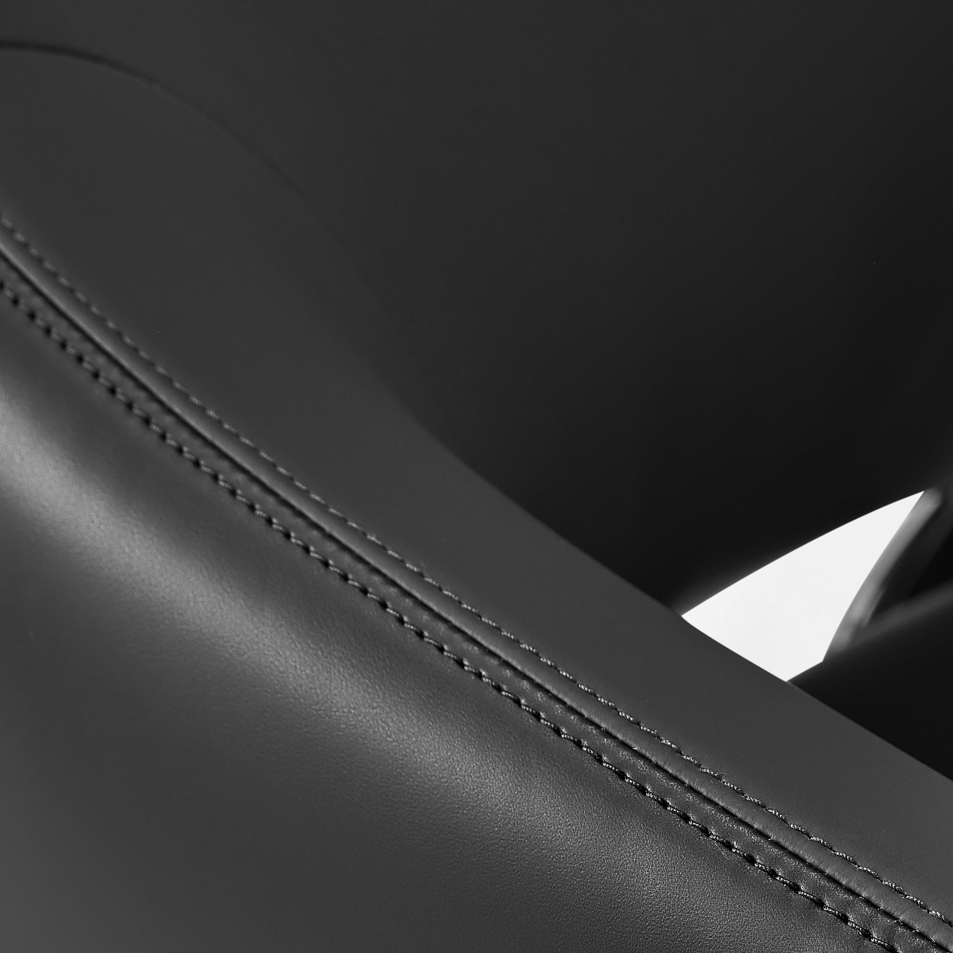 Eureka Ergonomic Serene Ella executive chair black Napa leather detail showing stitching on curved seam, material texture visible.