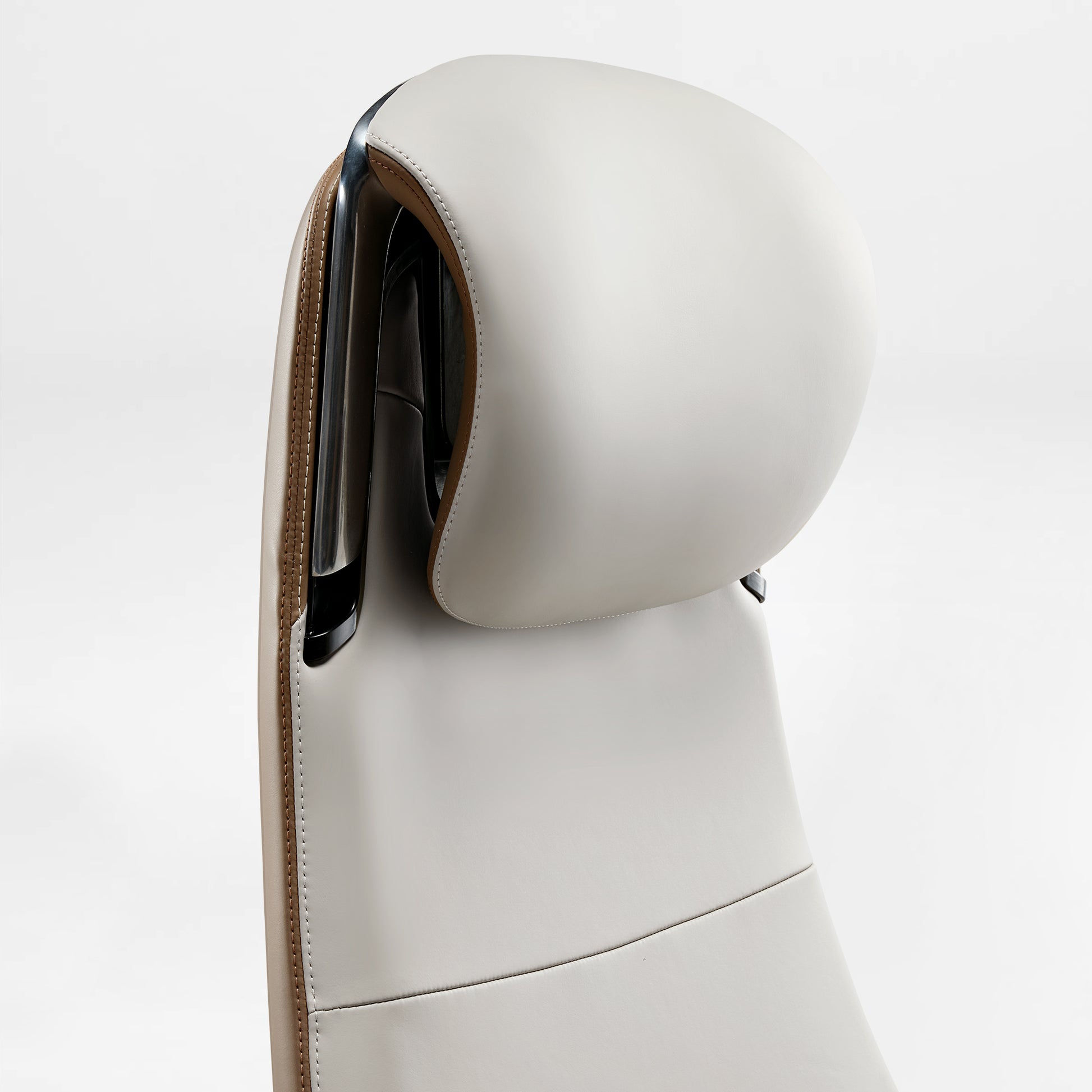 Eureka Ergonomic Close up of white Napa leather headrest and back on Serene Ella executive chair with tan leather trim and chrome accents.