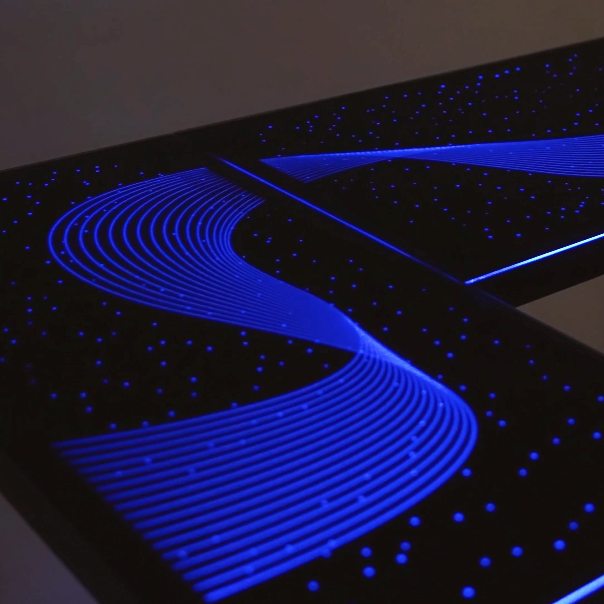 Eureka Ergonomic GTG L-shaped gaming desk with blue wave RGB lighting and starry night effect on black tempered glass surface.