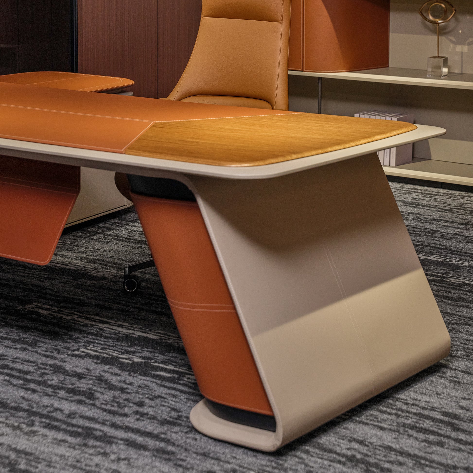 Eureka Ergonomic Zen Altair executive desk with warm wood inlay and bi-color orange/beige faux leather base on grey carpet.