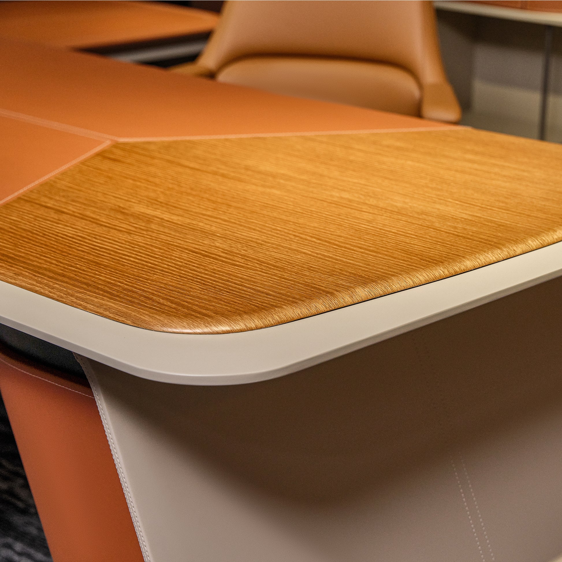 Eureka Ergonomic Zen Altair executive desk close-up: warm wood grain, orange faux leather with stitching, light gray trim.