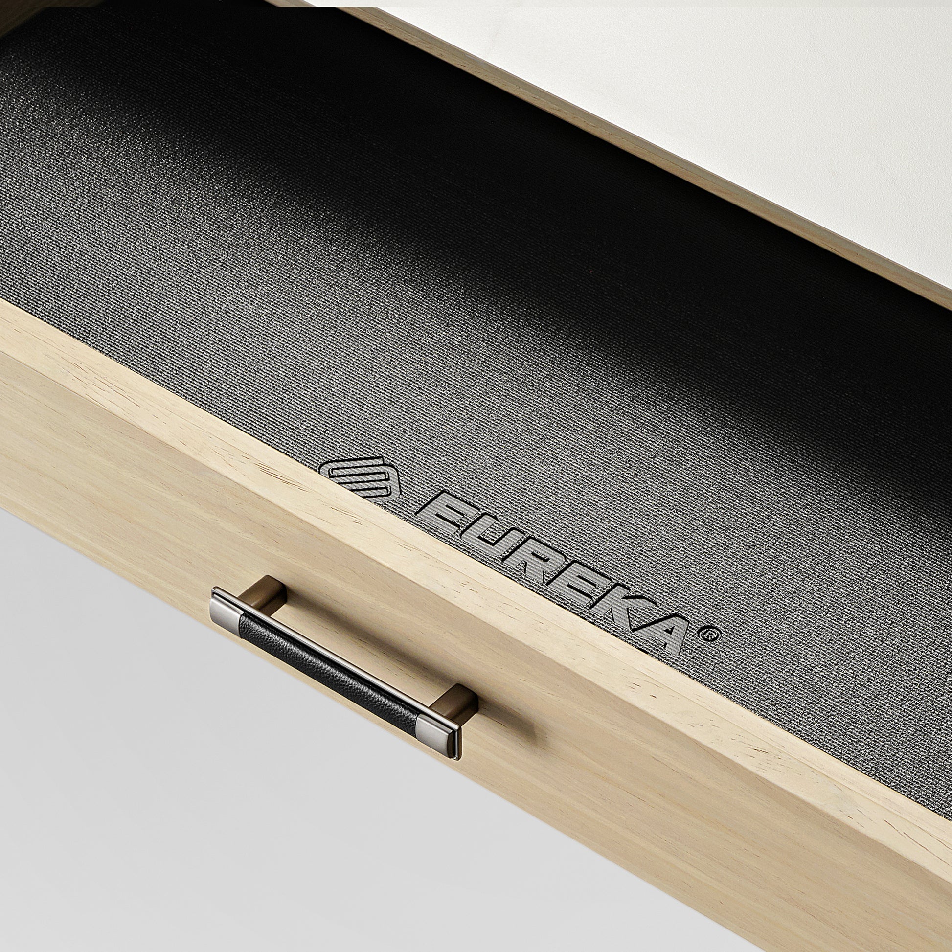 Eureka Ergonomic Desk Drawer Detail, Black Leather Grip, Wood, and Logo.