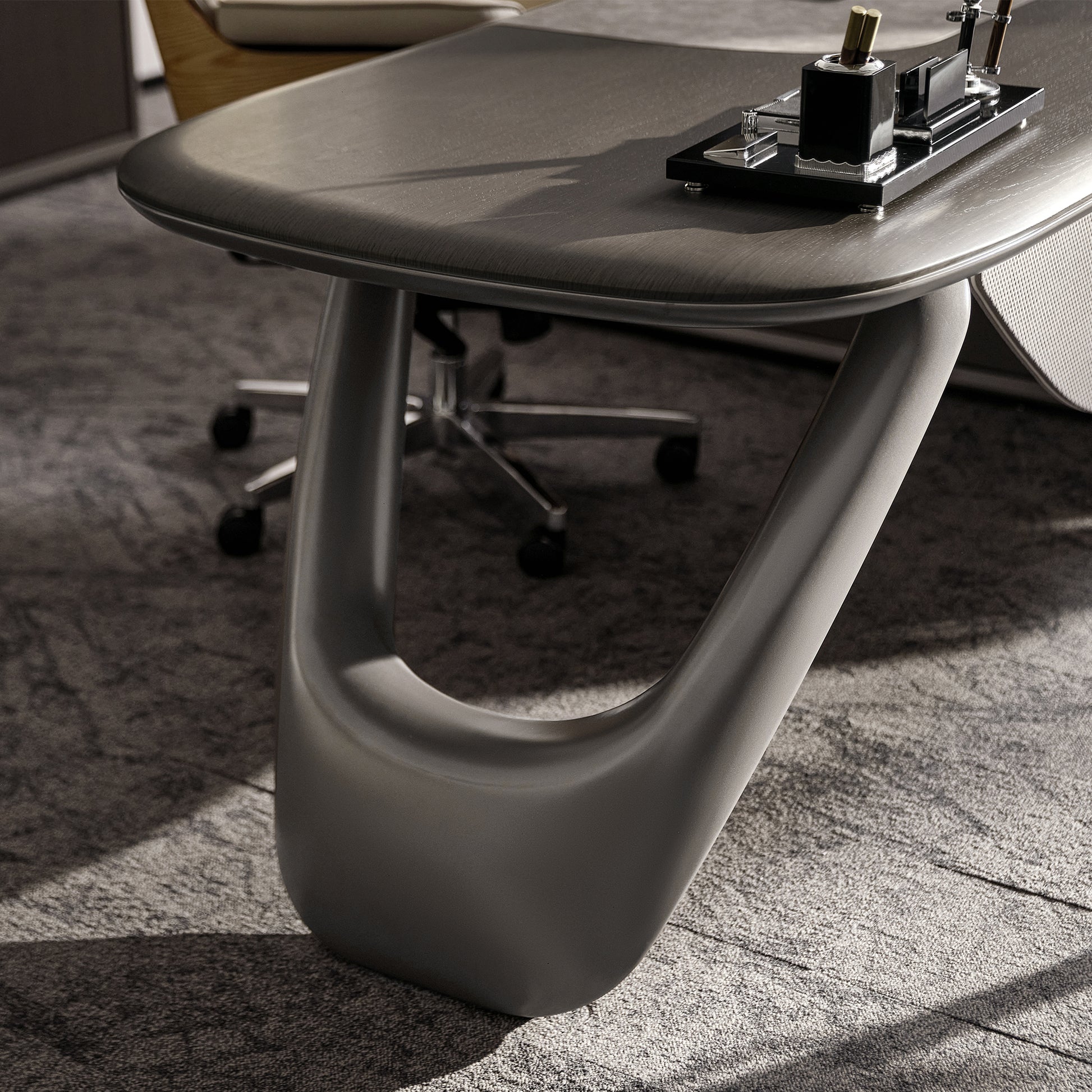Eureka Ergonomic Zen Orion executive desk close-up of dark wood grain top with matte gray U-shaped metal leg and desk organizer.