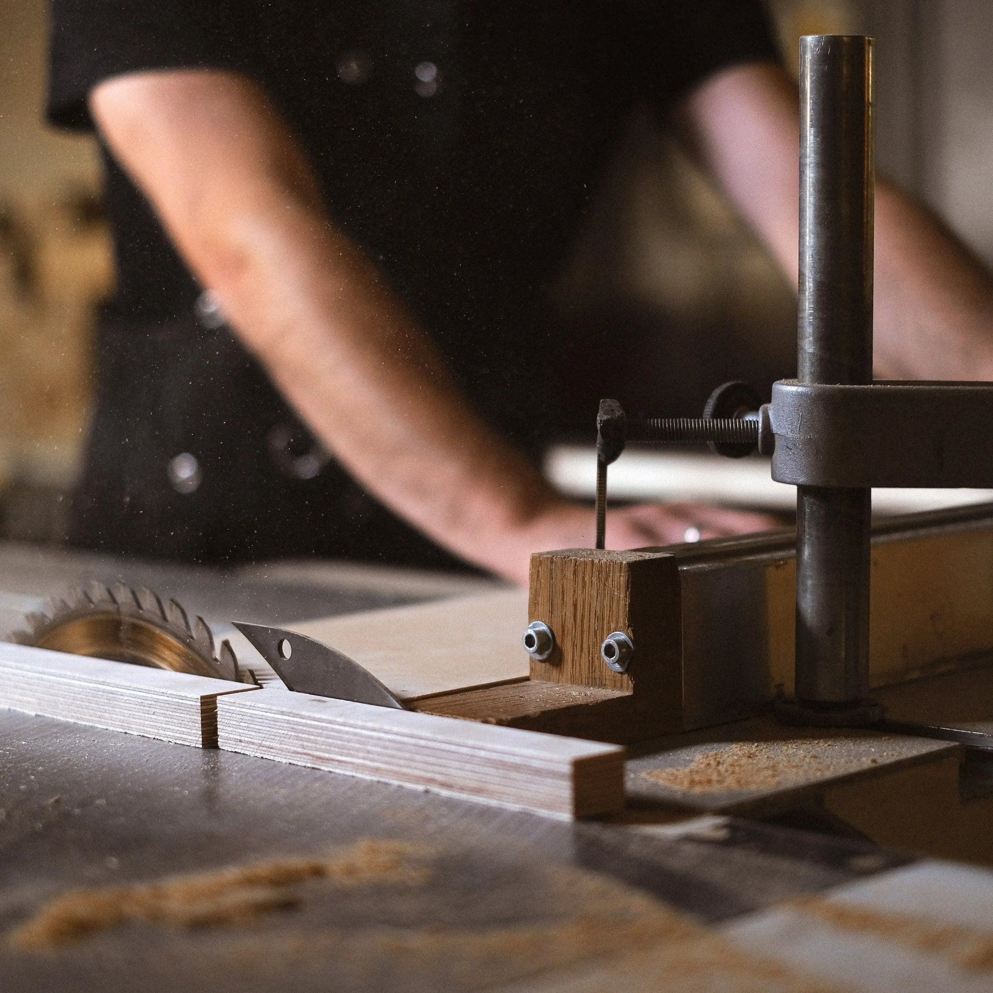 Woodworker Using a Table Saw to Cut Wood for a Standing Desk, Precision Cutting for Furniture Components.