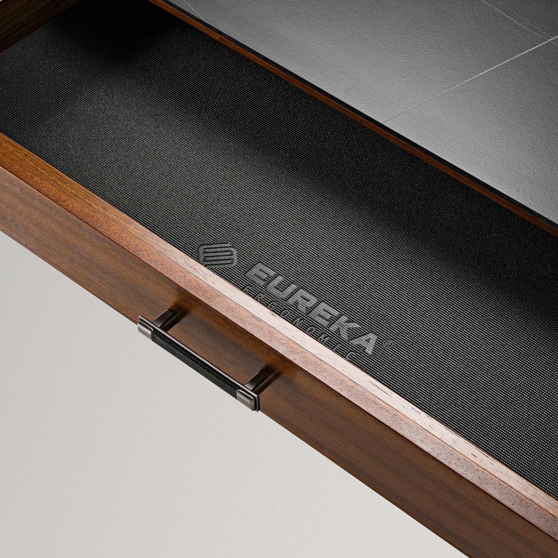Eureka Ergonomic Ark Pro Desk Drawer Detail. Black Leather Grip, Wood Grain, Black Sintered Stone Top.