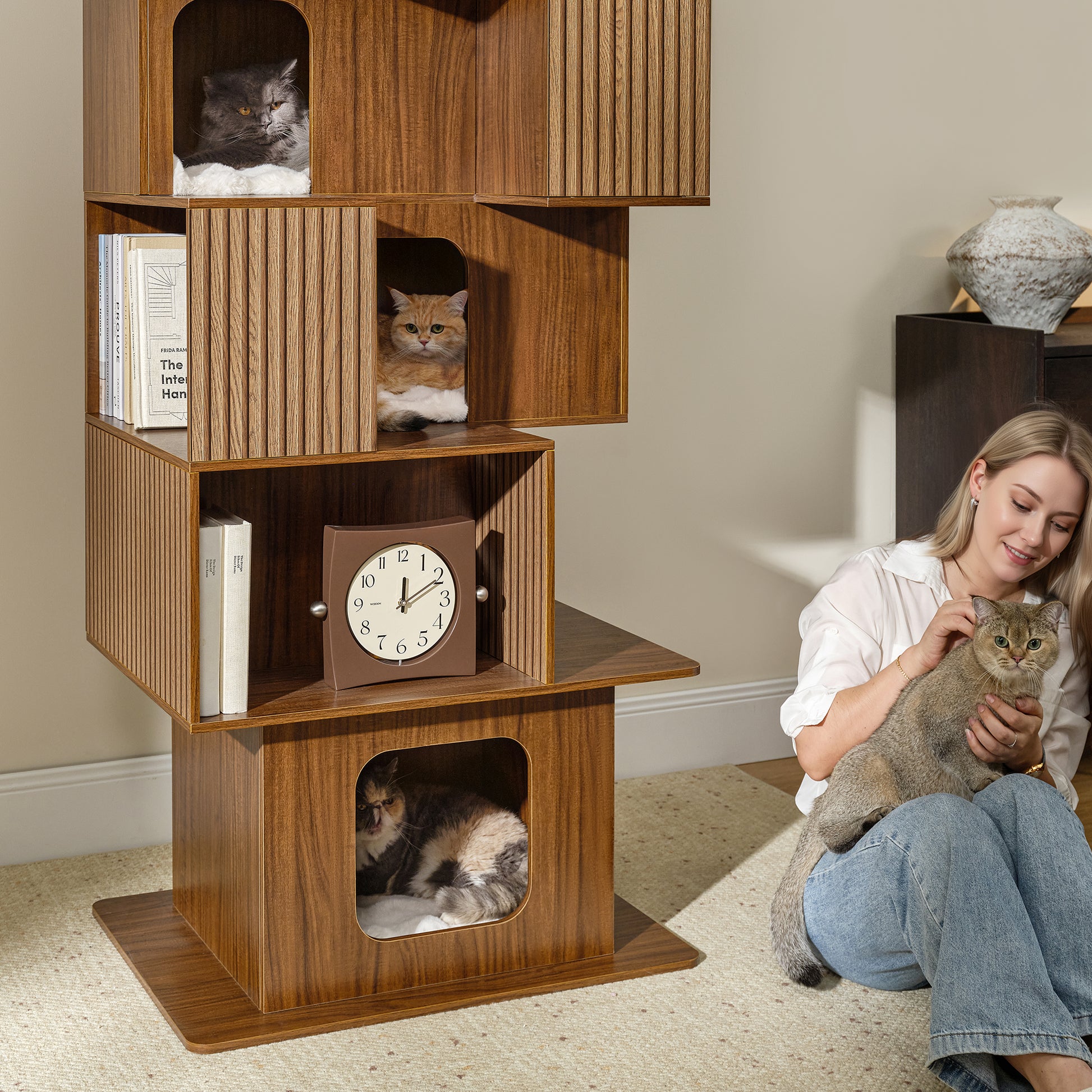 Eureka Ergonomic Owner and cat on rug next to Pawlio 72" wooden bookshelf cat tree with cats in cubbies.