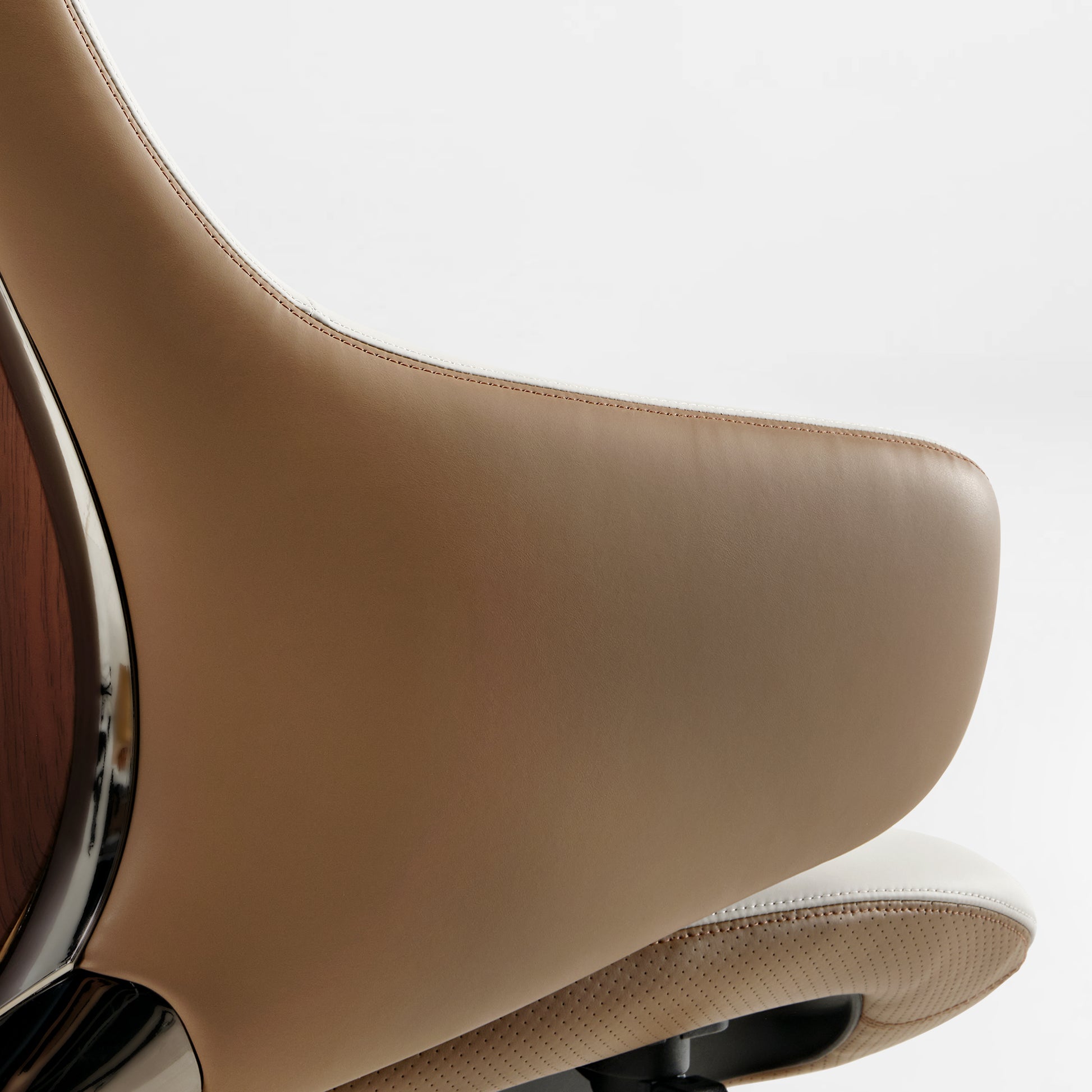 Eureka Ergonomic Serene Ella executive chair armrest close-up: tan Napa leather with white stitching, chrome accent and wood grain detail.