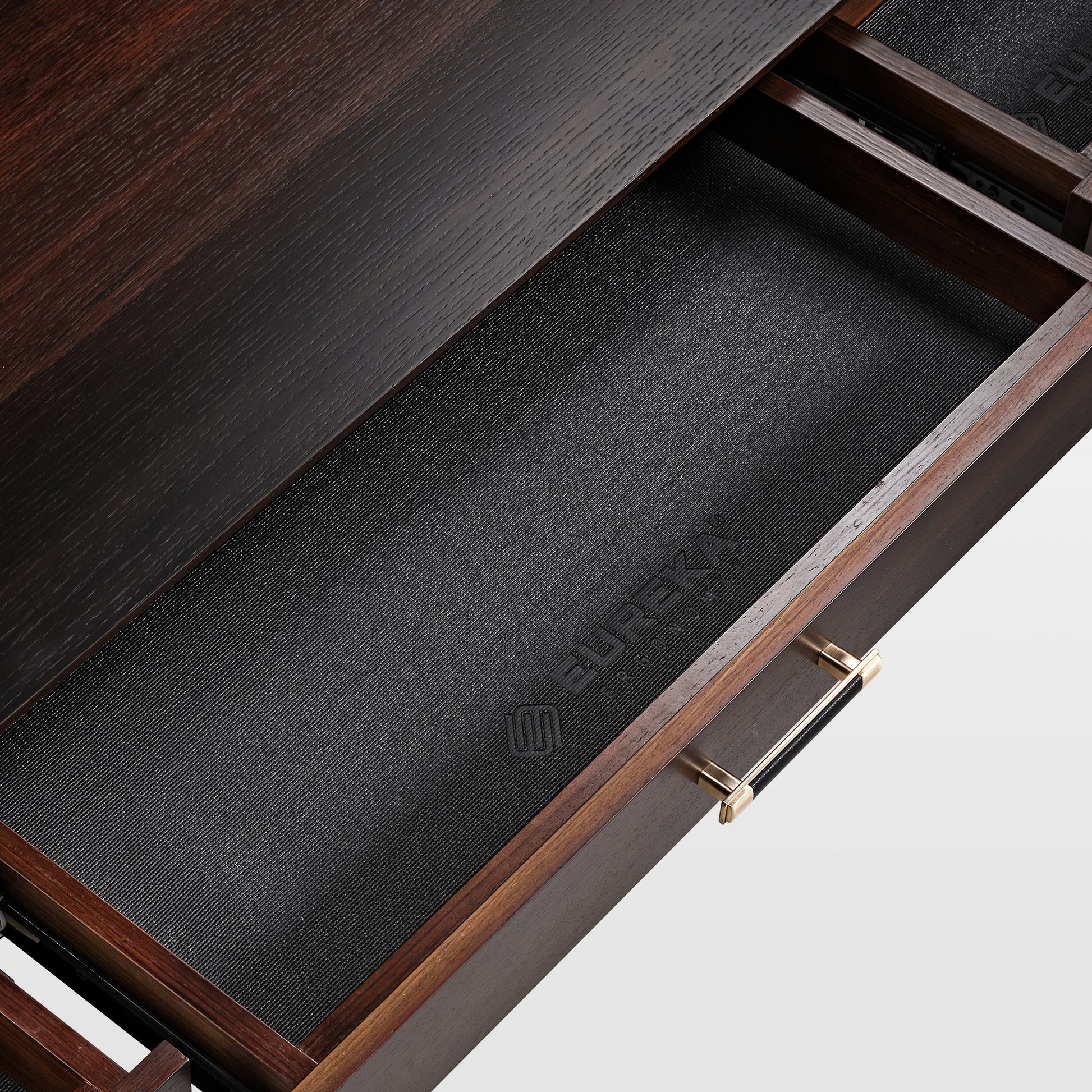 Ark Sws Pro Executive Desk Drawer Detail, Showcasing Dark Wood Grain, Gold Handle With Leather Grip and Eureka Logo.