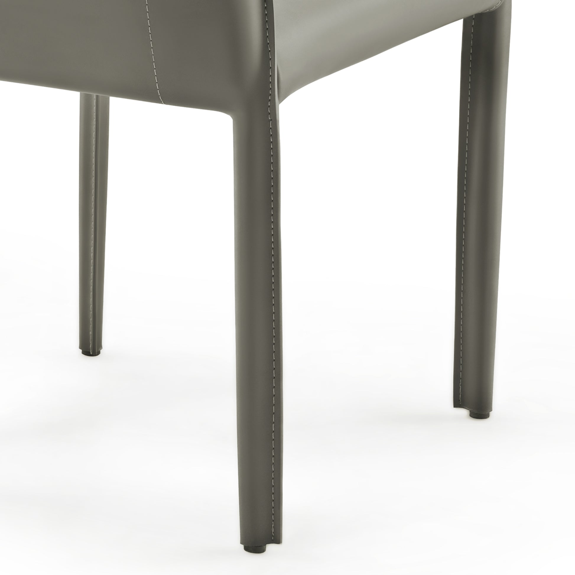 Gray Leather Dining Chair Leg Detail With White Stitching, Part of a Modern Dining Set.