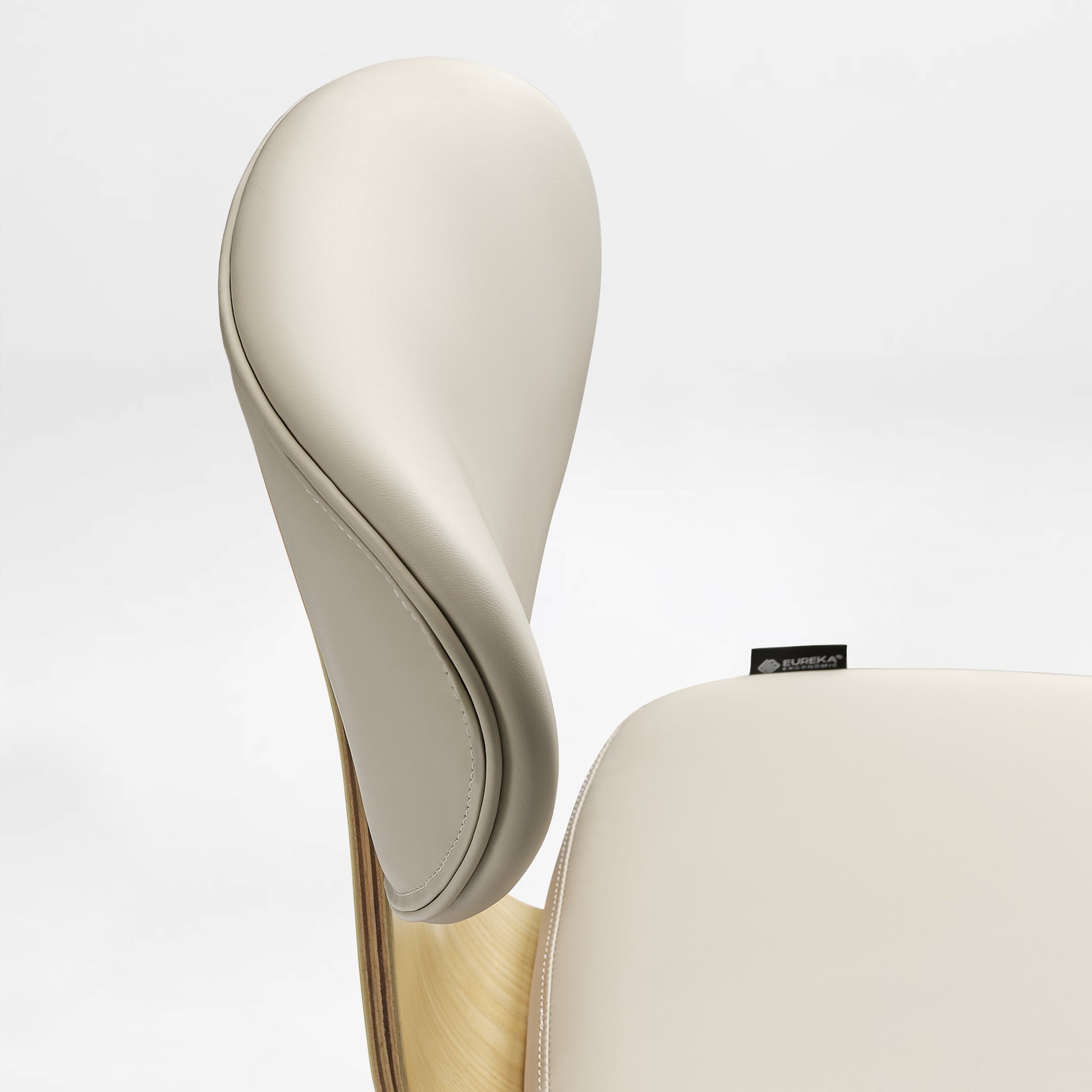 Eureka Ergonomic Off-white faux leather office chair close-up, showing stitching and light wood veneer shell.