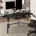 Black Eureka Ergonomic Aero Wing-Shaped Studio Desk With Accessories and Dual Monitors Setup.