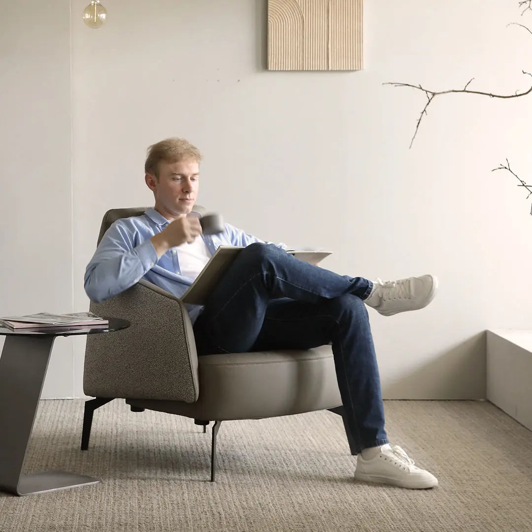 Man Relaxing in Napa Leather Ivory Lounge Chair With Coffee. Ergonomic Design and Modern Living Room Furniture.