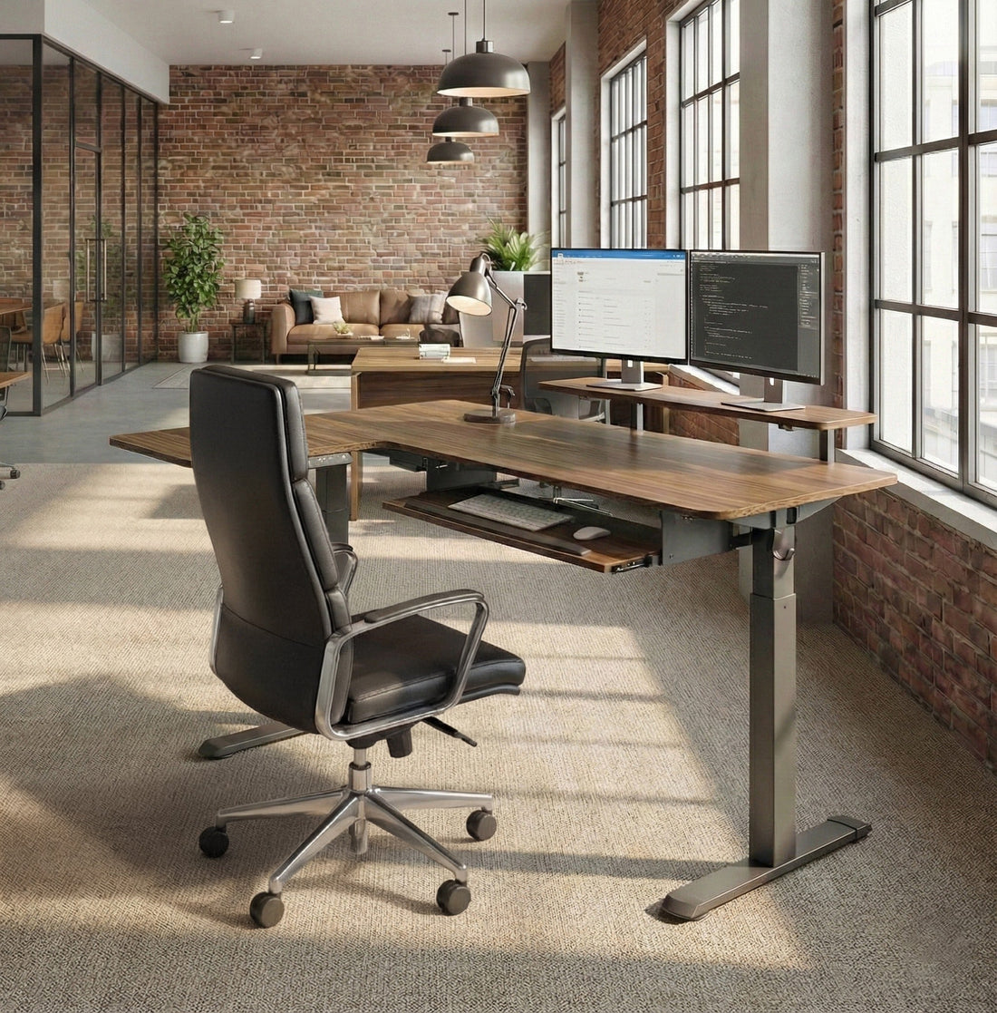 Walnut standing desk with dual monitors in a brick-wall office
