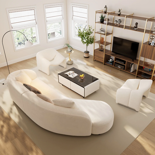 A modern living room with a curved white sofa and other light-colored furniture.