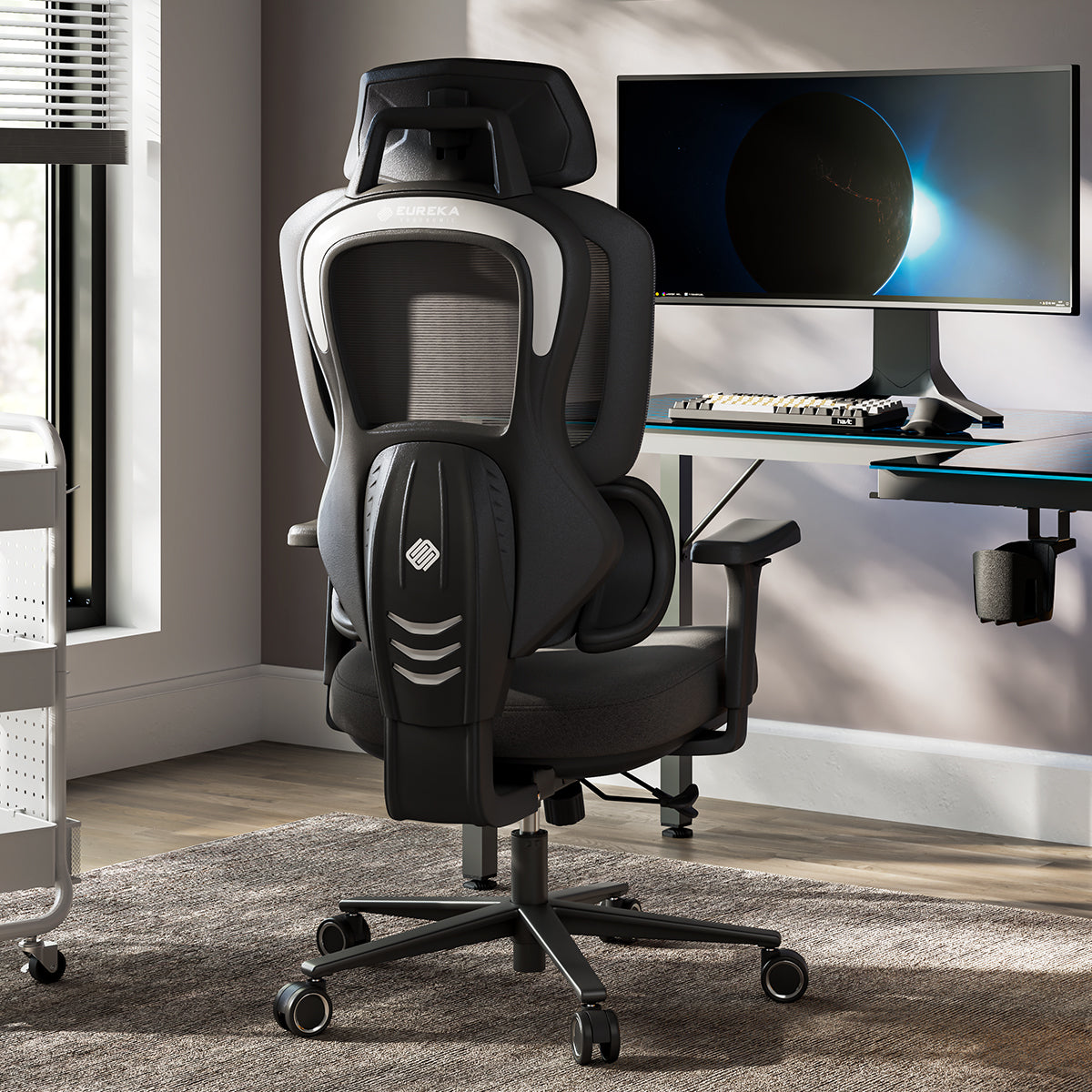 Typhon II Hybrid Ergonomic Gaming Chair in a modern office setting with a computer desk and monitor, black