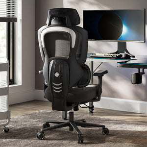 Typhon II Hybrid Ergonomic Gaming Chair in a modern office setting with a computer desk and monitor, black