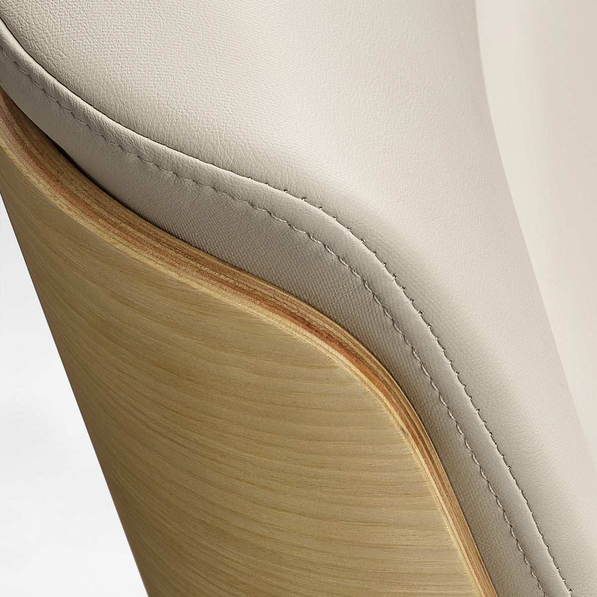 Eureka Ergonomic close-up of the beige Mathias Mason chair's oak back and leather upholstery seam
