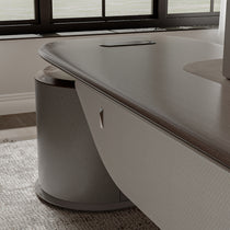 Eureka Ergonomic Zen Orion executive gaming desk: dark wood elliptical top, integrated cable management, rounded textured base, beige panel.