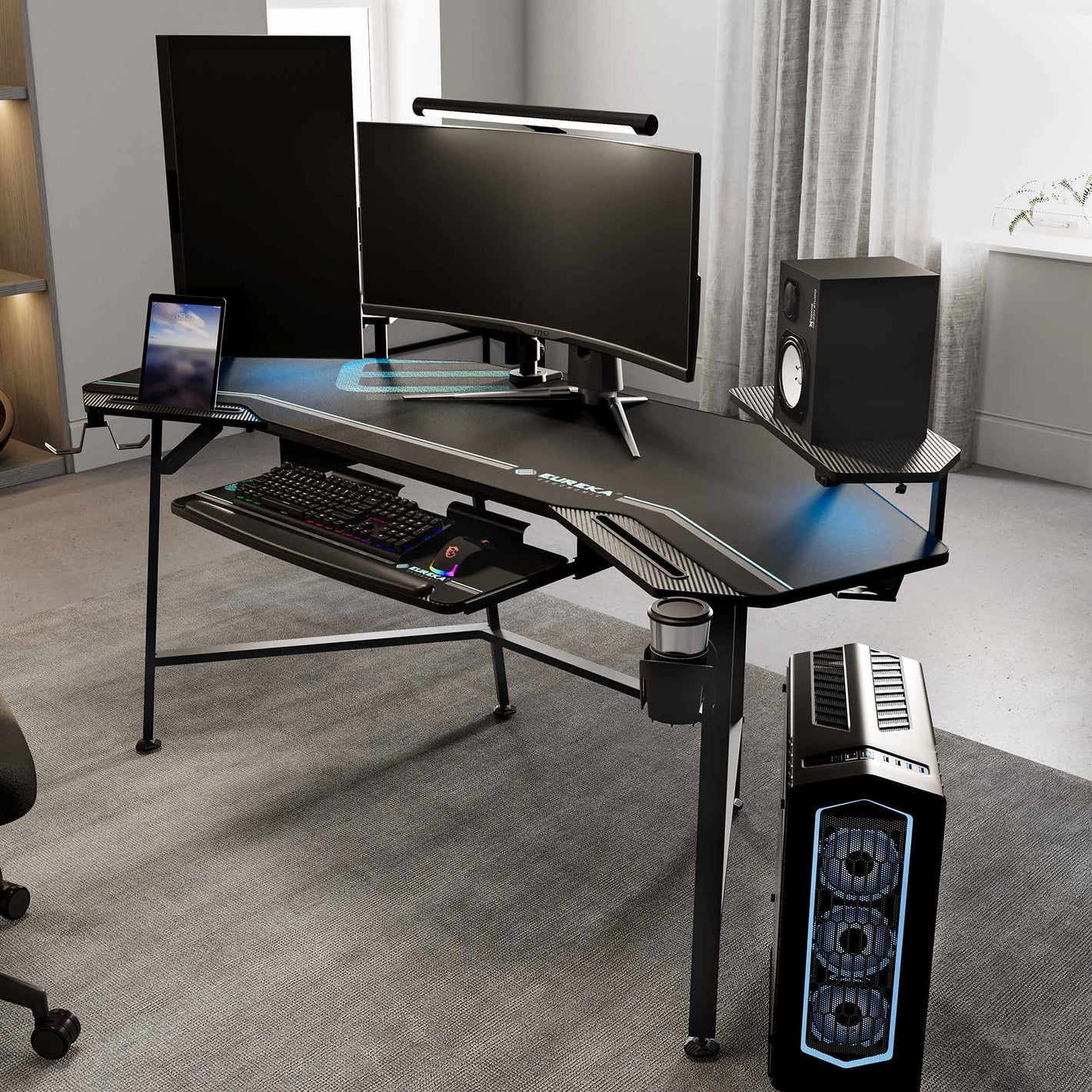 Eureka Ergonomic Wing shaped gaming desk setup with dual monitors, keyboard tray, PC, speakers, and RGB lighting.