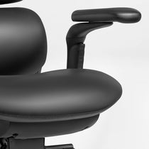 Eureka Ergonomic Black Forma ergonomic chair armrest and seat cushion detail, showing PU leather texture and stitching.