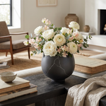 Eureka Ergonomic black vase with white flowers on a coffee table