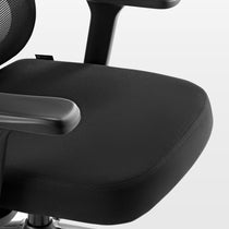 Eureka Ergonomic Close-up of Exis ergonomic office chair black fabric seat cushion, armrest, and mesh back. BUDEKA logo visible on seam.