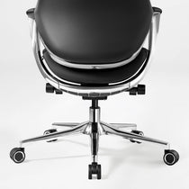 Eureka Ergonomic Nox black genuine leather executive chair rear view, showing polished chrome five-star base, casters, and metal frame detail.