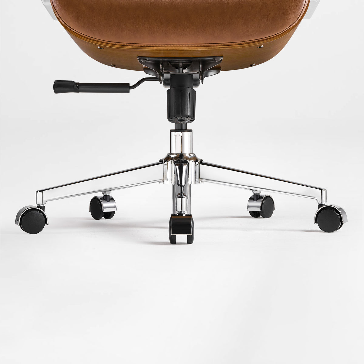 Eureka Ergonomic close-up of the brown Mathias Mason chair's chrome base, gas lift, and caster wheels