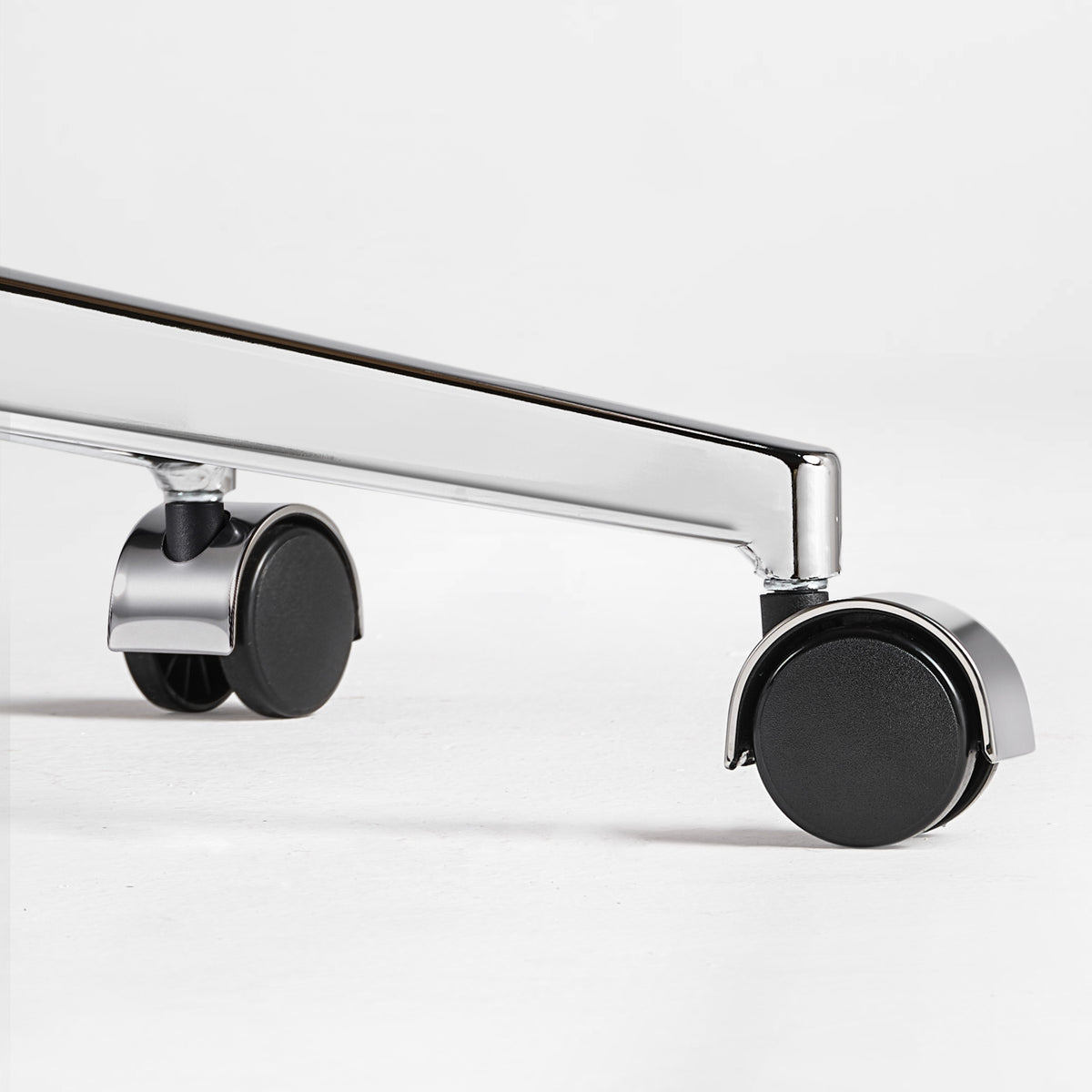 Eureka Ergonomic close-up of a caster wheel and polished metal base on the black Mathias Mason chair