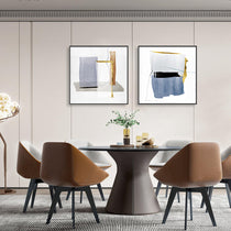 WA-04 Set of 2 Abstract Art Prints Above a Dining Table With Gold, Blue, and Gray Geometric Design.