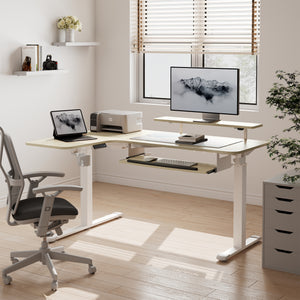 Eureka Ergonomic Light wood L-shaped standing desk with white legs, keyboard tray, monitor riser, laptop, and printer setup.
