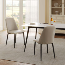 Off-White Upholstered Dining Chairs With Black Legs in a Modern Dining Room Setting.
