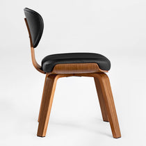 Eureka Ergonomic Belmar black leather dining chair with bentwood frame and tapered wood legs, shown on white background.