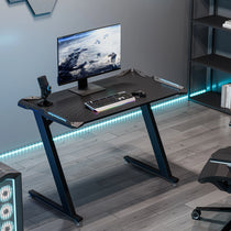 Black Gaming Desk With Z-Shaped Legs, Rgb Led Lighting, and Gaming Setup.