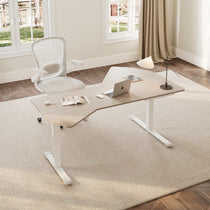 Eureka Ergonomic Blossom Dynamics L-shaped ergonomic office standing desk with light wood top, white base, laptop, mouse, and book in a home office.