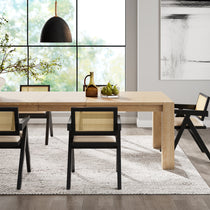 Eureka Ergonomic Four black Mila dining chairs with rattan backs and cream cushions around a light oak table.