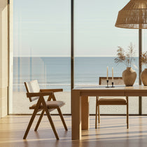 Eureka Ergonomic Edora Oak Extendable Dining Table with matte finish, shown in a bright dining room with ocean view and minimalist chairs.