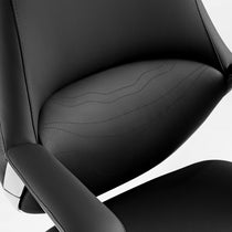 Eureka Ergonomic Nox black leather chair close-up: textured material, stitching, chrome accents.