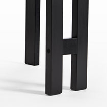 Eureka Ergonomic Close-up of Elle dining chair legs, matte black finish showing wood grain construction detail.
