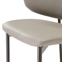 Noble Dining Chair Detail, Featuring Gray Faux Leather and Metal Legs, Perfect for Modern Dining Rooms.