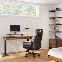 Eureka Ergonomic George Slate Standing Desk in a Modern Home Office Setup, With Black Leather Chair, Monitor and Bookshelf.
