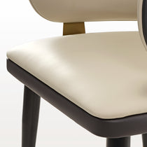 Anareli Dining Chair Detail: Beige Faux Leather Seat and Dark Brown Trim, Golden Accents, Modern Design.