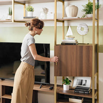 Sonoma Modern Tv Stand With Storage Cabinet and Bookshelf, Featuring a Woman Opening the Cabinet Door.