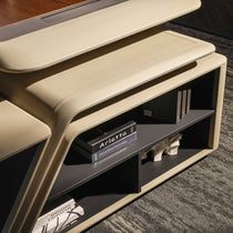 Eureka Ergonomic Zen Lunar executive desk close-up with beige leatherette and dark wood top, featuring integrated bookcase with books.