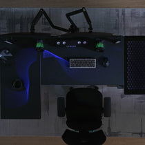 Eureka Ergonomic Overhead view of GTG L-shaped gaming desk with blue wave RGB lighting, dual monitors, keyboard, mouse, and cup holder.