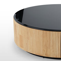 Round Coffee Table With Black Glass Top and Grooved Wooden Base, Fingerprint Glass Logo Detail, Modern Living Room Furniture.
