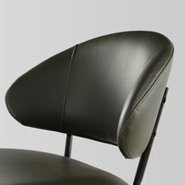 Finn Dining Chair Detail in Green Faux Leather With Black Steel Frame.